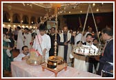 A child puts his offering on the scales during the Tulsi-Tula