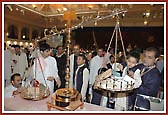 A child puts his offering on the scales during the Tulsi-Tula