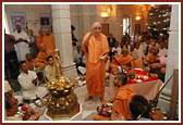 Swamishri showers devotees with rice grains in blessing