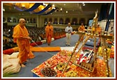 Swamishri devotionally swings Thakorji on a golden swing