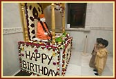 Children praying by the murti of Pramukh Swami Maharaj