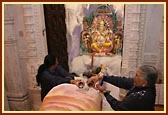 Devotees offering their devotion by performing abhishek of the Shivling with milk and bilipatras