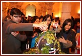 Devotees offering their devotion by performing abhishek of the Shivaling with milk and bilipatras