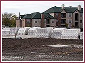 Carved stones from India on new parking lot for storage  