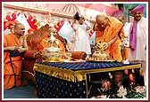 Devotees invite Swamishri to Chicago as Pujya Viveksagar Swami ceremoniously breaks the coconut of a kalash made entirely of sweets  