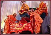 Pujya Viveksagar Swami and Pujya Ghanshyamcharan Swami present a shawl with the words of 