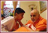 Swamishri attentively listens to a young child