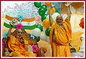 Swamishri and Pujya Ghanshyamcharan Swami joyously wave their hands