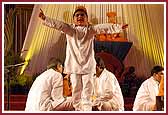 A child dances jubilantly as saints and devotees sing kirtans 