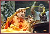Swamishri sprays colors on Shri Harikrishna Maharaj 