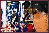 Pujya Doctor Swami places flowers on the scale