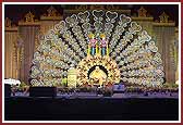 Swamishri and Shri Harikrishna Maharaj seated on a grand sinhasan at the program