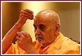 Swamishri applies a tilak to his forehead