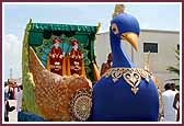 Shri Akshar Purushottam Maharaj seated on a Peacock float