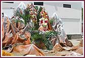 Shri Shiv, Parvati, and Ganeshji seated on a float in the shape of Mount Kailash.