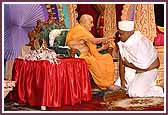 Swamishri applies chandan to the foreheads of initiates