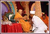 Swamishri applies chandan to the foreheads of initiates