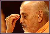 Swamishri touches a prasadi bead to his eyes