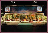  Swamishri seated on stage amidst a garden-like setting  