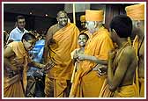 Balaks dressed as saints receive Swamishri to the Swagat Sabha