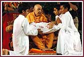 Swamishri is presented with a pillow embroidered with the words 'Vicharan to My Heart', made by the Balika Mandal