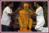 Bal Mandal National Development Committee members present Swamishri with a garland made by the balika Mandal 