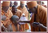  Swamishri personally meets a child dressed as a sadhu 