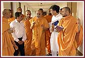 Swamishri answers a devotee's question on his way to pooja  