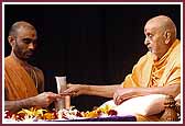 Swamishri sanctifies water with prasadi cloth  