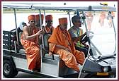 Swamishri arrives at the airport lounge in a golf cart