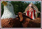 Shri Ghanshyam Maharaj seated on an eagle float