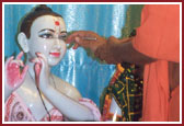 Swamishri performing idol installation of Radha Krishna