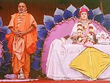 Pramukh Swami on stage, begging for alms for the social and religious activities of the sanstha