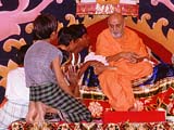 Swamishri encouraging tribal children, Atladra
