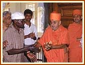 After performing arti Swamishri gives the last round of arti to Mustafa 1 Oct 99