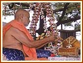 Swamishri first sprinkles colored water on Harikrishna Maharaj