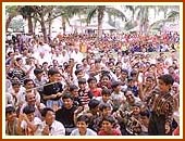 Swamishri sprinkles colored water on the enthusiastic devotees and children