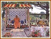 Swamishri seated on a swing decorated with flowers