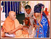 Swamishri inquiring and inspiring a tribal child, "How many malas do you do everyday ?...