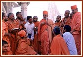 Calmly sharing words of wisdom and humor to an audience of sadhus and devotees