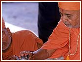 Performing Yagna rituals for the Murti pratishtha Ceremony:  Bathing Lord Harikrishna Maharaj with water