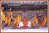 Swamishri holding hands with kishores during a folk dance