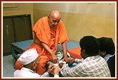 Swamishri casually sits on an ordinary platform and discusses and gives guidance to a few devotees on a personal matter
