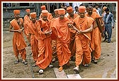 Despite the soggy ground Swamishri walks on to see the construction work