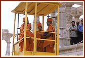 Being elevated to the mandir floor in a cabin by the construction crane