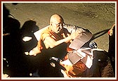 ... During which Swamishri is engrossed in reading letters in the dim light