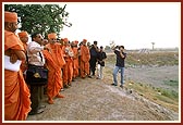 Explaining the boundary and contours of the land to Swamishri