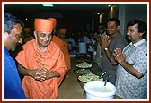 Swamishri happily observes the prasad to be served to the devotees