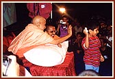 Swamishri entertains boy trying to grab a packet of prasad