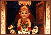 Darshan of Lord Ghanshyam Maharaj through a decorated window in the mandir sanctum